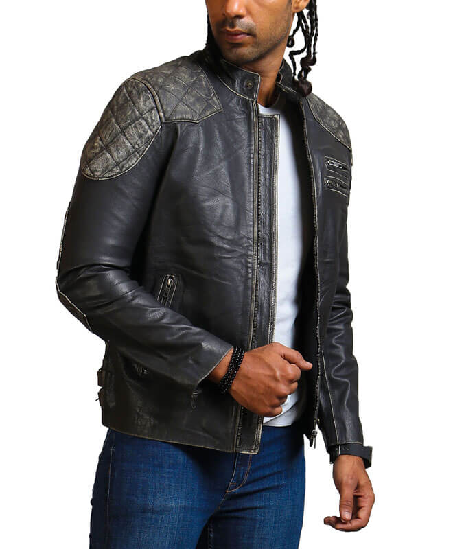 Man wearing a black leather jacket with quilted shoulder panels on a white background